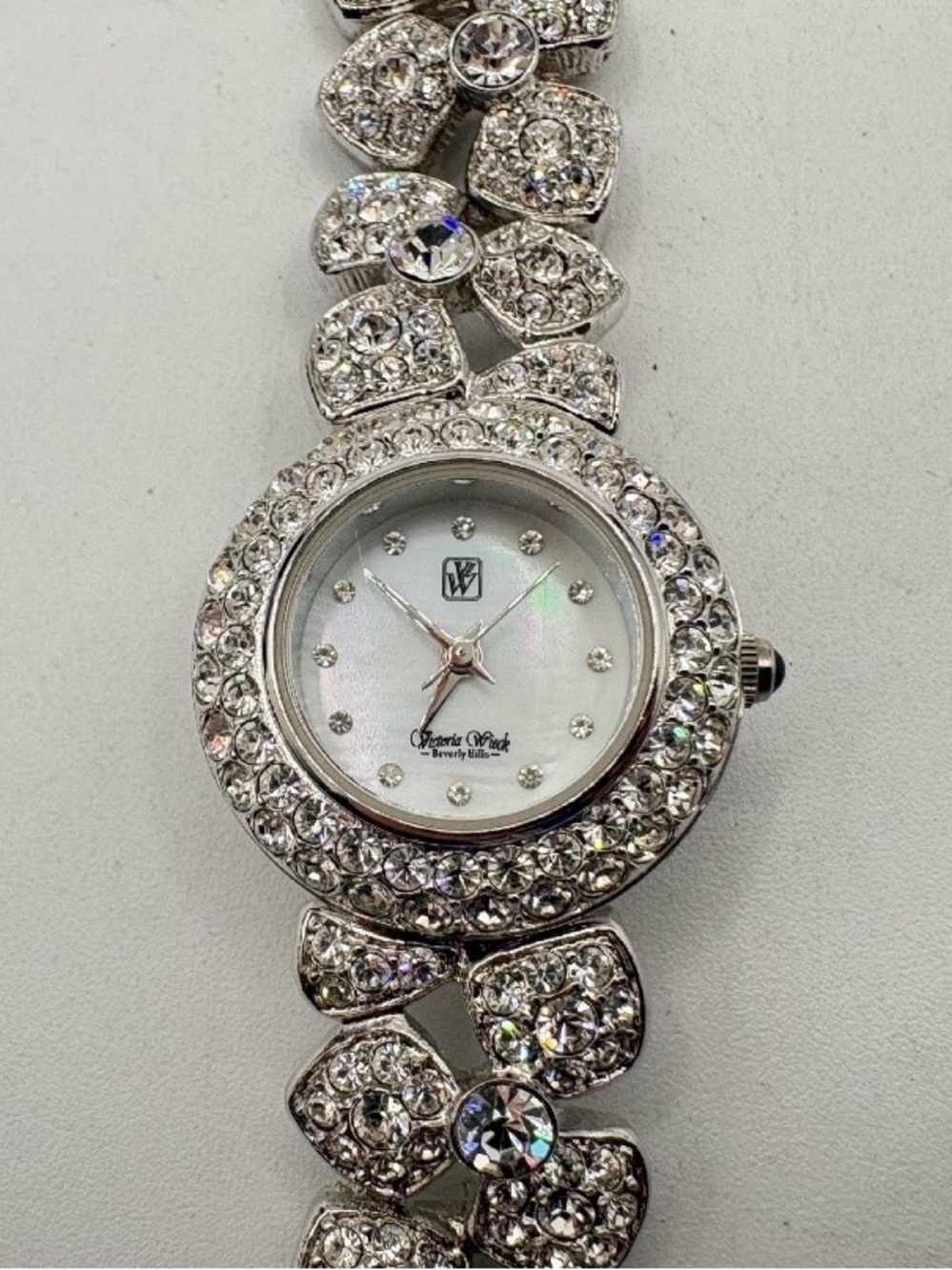 Victoria Wieck rhinestone watch w/floral link band a crystal accented dial.